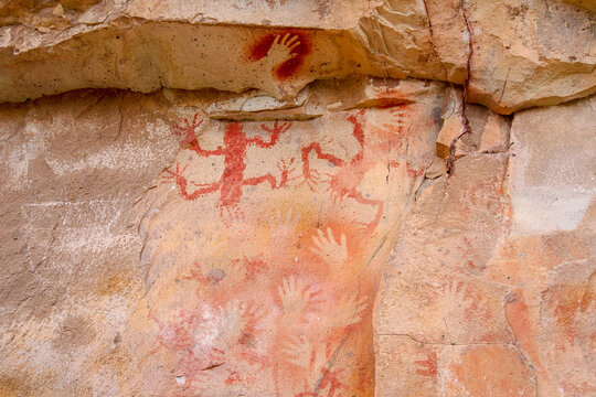 Close up of colourful animal rockpaintings and handprints on rock walls at Cueva de las Manos, UNESCO World Heritage Site, Patagonia, Argentina