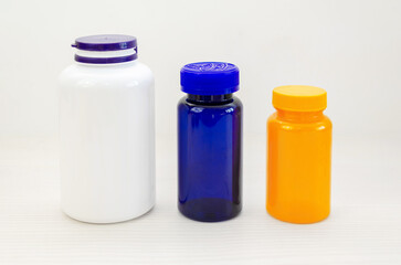 Empty colored plastic bottles for vitamins or medicines on white background