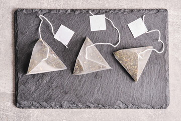 Triangular teabag with tea on a slate.