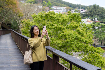Tourist woman use mobile phone to take photo in the walking trail in the forest - 762414604