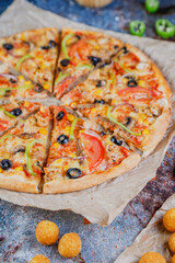 Hot tasty traditional various italian pizzas with salami, meat, cheese, onion, mushroom, tomatoes greens on a dark background