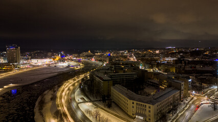 Drone photography of night city lights and river during winter night