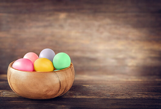 Easter eggs in a wooden bowl on a wooden background. side view. space for text