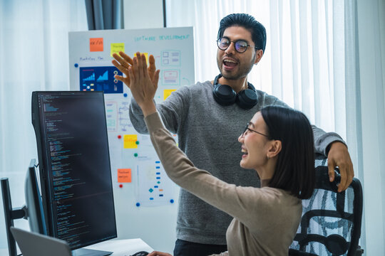 asian and Indian Developer team clapping hand for project success  with software computer at office