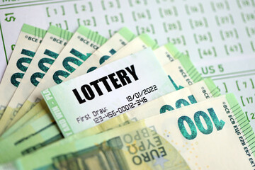 Green lottery tickets and euro money bills on blank with numbers for playing lottery close up