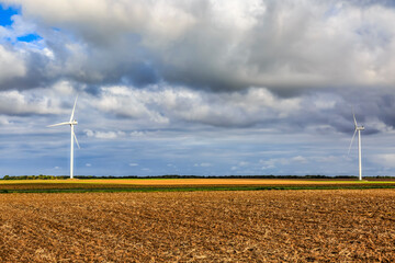 Plain field in autumn with wind turbines