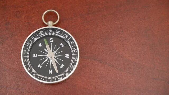 Compass on table with rotating pointer, copy space for text.