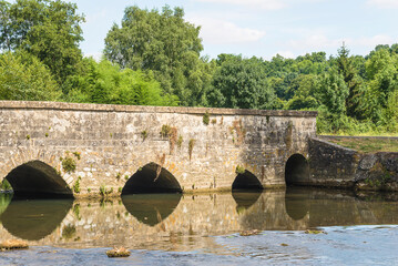 Old stones bridge and river on summer sunny day