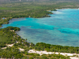 Drone view of coastline in Tulum with turquoise Caribbean Sea and green tropical vegetation on a sunny day