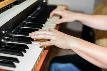 Fototapeta premium Close up view of Caucasian hands playing electric piano in bedroom