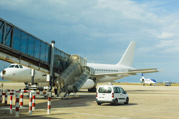 Fototapeta na wymiar Passenger plane on runway with boarding tunnel and stairs before take off