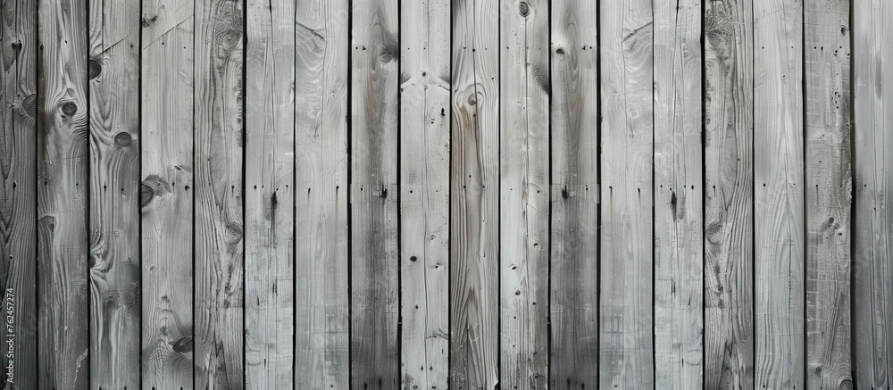 Poster an image capturing the intricate pattern of a grey wooden fence against a backdrop of lush green gra