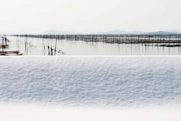 Obraz premium Snowy seaside at the laver seaweed farm