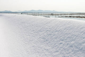 Obraz premium Snowy seaside at the laver seaweed farm