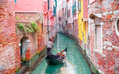 Poster Venetian gondolier punting gondola through green canal waters of Venice Italy © muratart