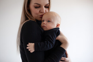 A beautiful girl in black golf holding  her two month old baby