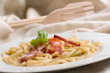 Pici senesi alla checca or Pici pasta from Siena Tuscany with mozzarella, basil, cherry tomatoes  and Tuscany lonza salami