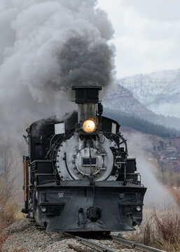 Vintage Steam Train Billowing Smoke and Steam as it Moves Through the Mountains.