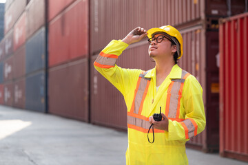 Asia logistic engineer man worker or foreman working with walkie talkie at container site	 - 762476869