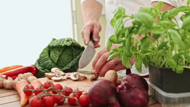 A man chops vegetables on a cutting board for a fresh dish