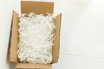 White shredded paper in cardboard box.