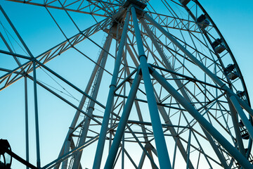 part of the Ferris wheel on a blue sky background, bottom view