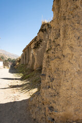 Ruinas de paredes antiguas construidas de adobe, pueblo rural, día soleado