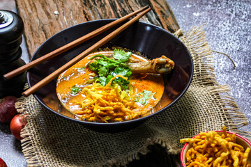Northern Thai food (Khao Soi Kai), spicy egg noodles soup with chicken in a bowl