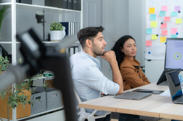 Obraz premium Multiethnic startup business team on meeting in modern bright office interior brainstorming, working on laptop and tablet computer