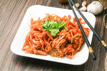 Pad Thai, a famous food of Thailand Served on white plates and wooden tables in a restaurant