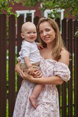 Fototapeta premium young beautiful mother holding her baby son in her arms