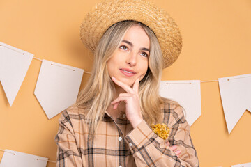 thoughtful young woman to Festa Junina in Brazil in beige colors. thinking and looking to the side 