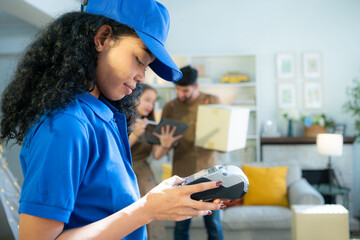 Portrait of a female delivery worker using a card reader to verify the delivery of goods to a...