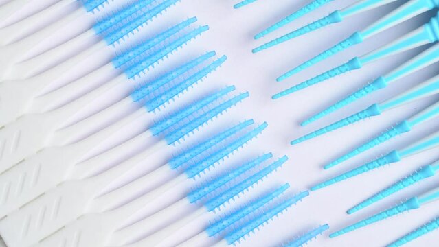 Different dental toothpick brushes rotation on white background, macro shot. Soft silicone flossing toothpicks.