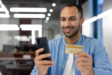 Smiling man shopping online with credit card and smartphone