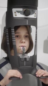 A dental X-ray machine takes a picture of the baby's baby teeth and jaw. Diagnosis and examination using high-tech medical equipment of the dental clinic. The patient is at a doctor's appointment.
