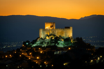 castle on top of a mountain illuminated at dusk