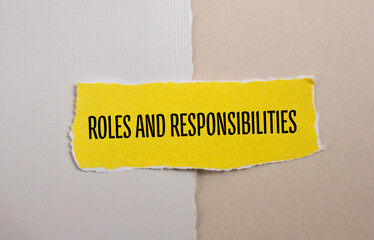 Roles and responsibilities words written on yellow torn paper. Conceptual symbol. Copy space.
