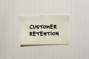 Customer retention words written on torn paper piece with notepad background. Conceptual business symbol. Copy space.