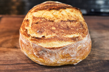 home made loaf of white bread resting on the countertop in the kitchen 