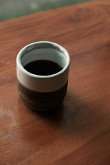 Brewing v60 filter coffee in an aesthetic ceramic cup on a wooden table