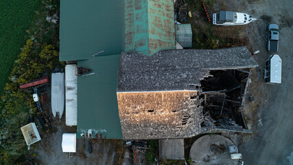 An aerial shot of a dilapidated Barn on a farm at sunset