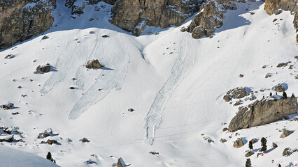 Avalanches after heavy snowfall in the alps. Picture taken in ski resort the Dolomites, Italy (Dolomiti Superski). The stripes on the right side of the picture are hiking trails.