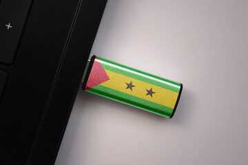 usb flash drive in notebook computer with the national flag of sao tome and principe on gray background.