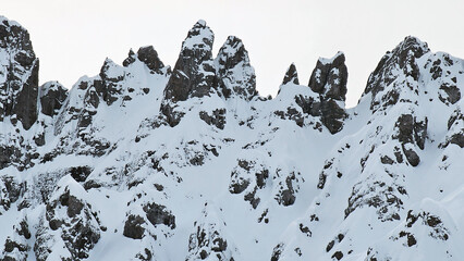 Mountain silhouette and close up structure of Dolomites rocks after heavy snowfall with blue sky. 