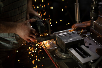Metal sawing. Work in garage. Sparks from cutting steel.