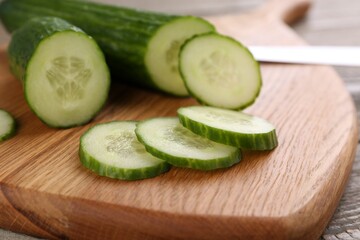 Fresh cucumbers on wooden cutting board, closeup