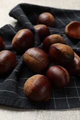 Roasted edible sweet chestnuts on light table, closeup