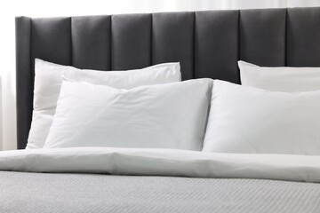 Fototapeta na wymiar Soft white pillows and duvet on bed