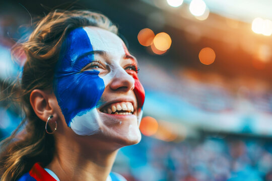 Happy French female supporter with face painted in French flag displaying the country's national colours: blue, white, and red